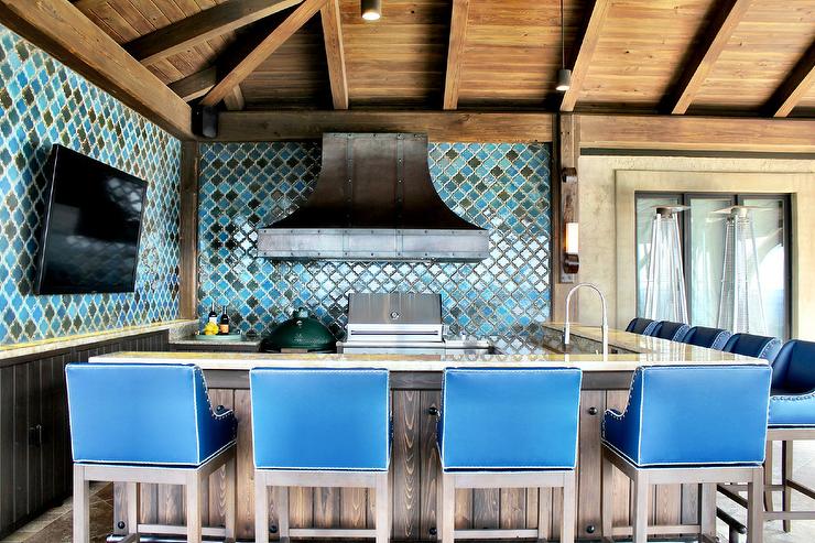 Cuisine de style méditerranéen ouverte sur le jardin. Mosaïque bleue aux murs en correspondance avec la couleur des chaises de bar Très sympa cette cuisine en aménagée sur une terrasse en bois.