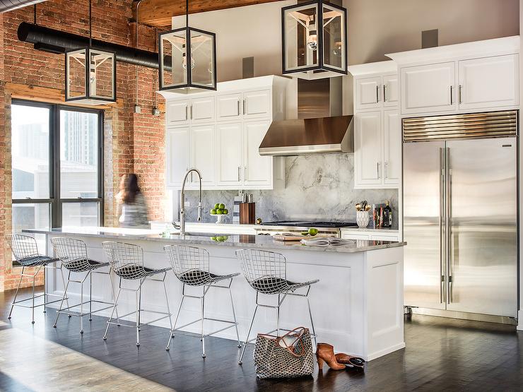 Époustouflant cet aménagement! cuisine contemporaine nichée dans un loft aux briques rouges. Ilot central qui accueille 5 chaises design