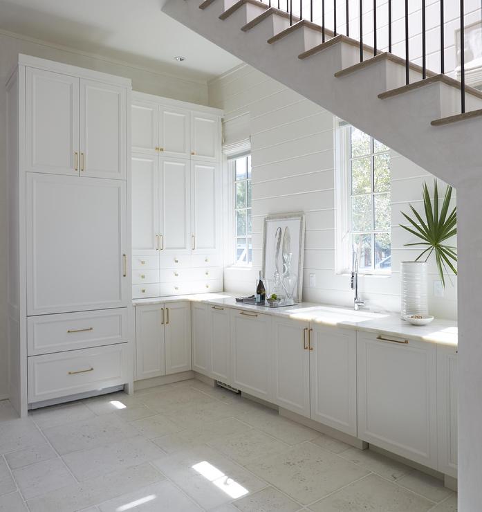 Cuisine tout équipée aménagée sous un escalier blanc avec un évier sous plan Petite cuisine ouverte aménagée sous l'escalier.