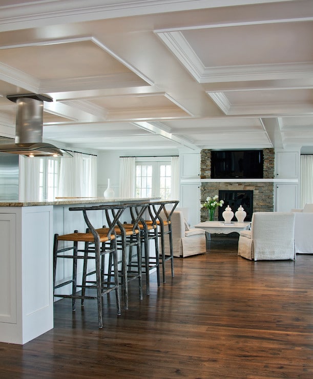 Une grande cuisine contemporaine donnant sur un salon raffiné Le blanc du faux-plafond combiné aux façades colorées crée une ambiance lumineuse.