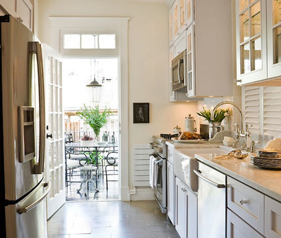 Décoration blanche pour donner à votre cuisine un air de campagne avec plan de travail en marbre et évier en céramique intégré avec robinet mélangeur. Rangements en hauteur, frigo américain et carrelage classique. idée d'aménagement d'une petite cuisine. Source: https://www.decorpad.com/paint-brand/Benjamin-Moore/Soft-Chamois