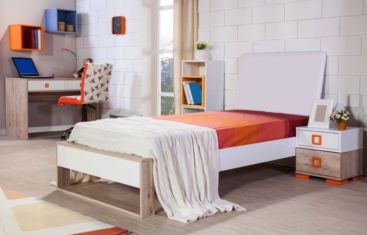 Chambre d'enfant design sobre couleur douce, lit en bois et chevet assorti. Bureau avec chaise à roulettes, étagères murales en forme de cube. Mur décoré effet briques blanchies.
