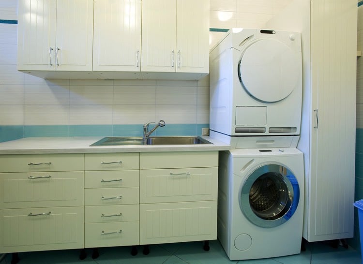 Une petite buanderie bien aménagée avec machine à laver et rangements de type cuisine.