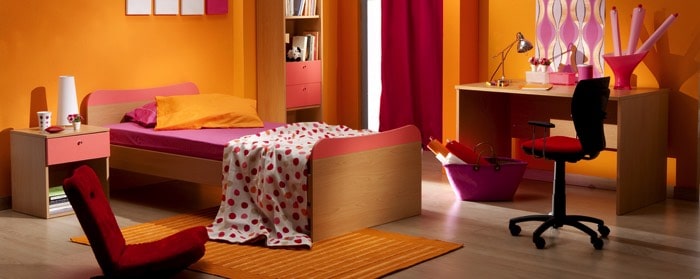 Décoration jaune moutarde pour une chambre d’ado fille. Lit bois rose une place, couverture blanche à petits pois, parquet et bureau avec chaise noire à roulettes. chambre-ado-fille-room27-01