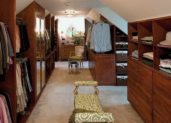 Dressing dans les combles style gustavien avec rangements en bois noyer des deux côtés. Moquette beige avec chaise et canapé ainsi que portes avec miroirs.