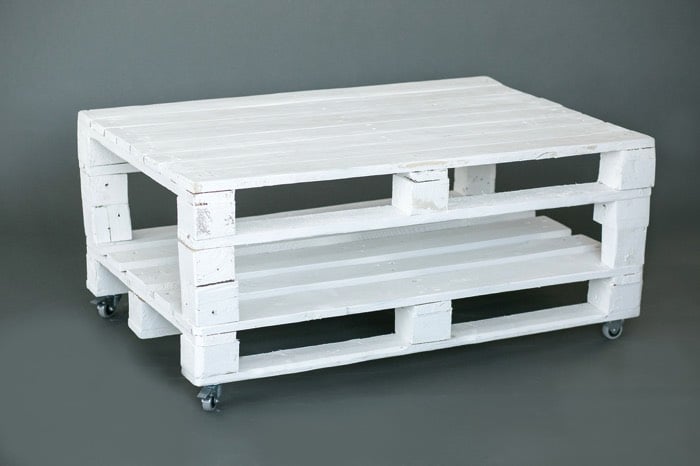 Fabriquer une table basse peinte blanc en palette et munie de quatre petites roues grises et noires. Espace prévue en-dessous pour rangement. fabriquer-table-basse-palette-279photo-studio-4