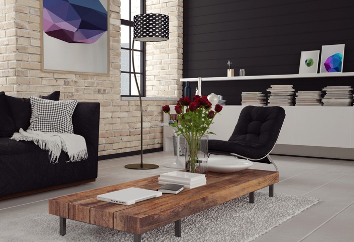 Table basse en bois teck à plusieurs pieds. Tapis blanc sur carrelage avec mur en briques beiges et fauteuil noir.