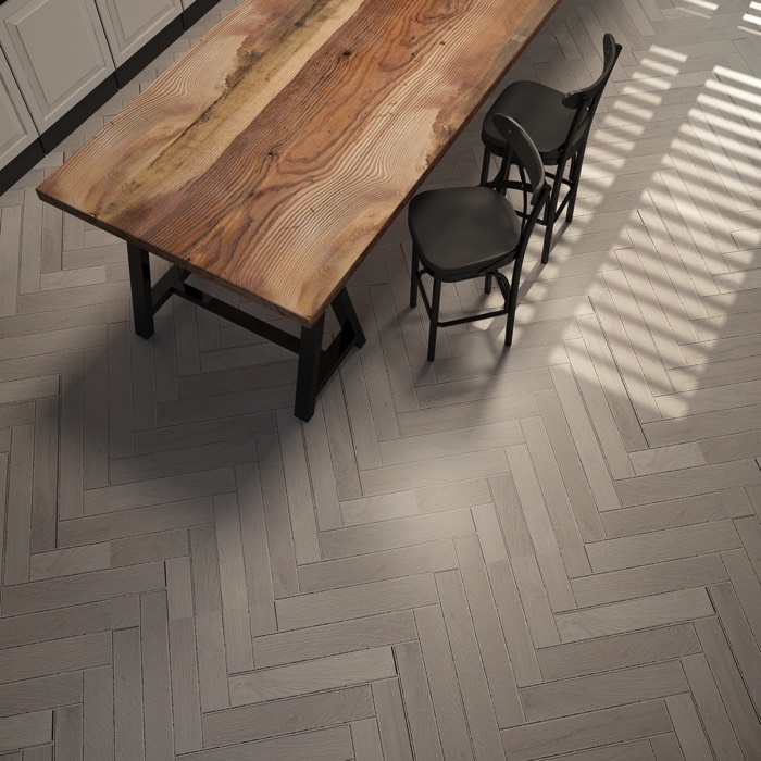 Table salle à manger classique en vieux bois tech sur carrelage blanc avec rayures. Deux chaises noires style bar.
