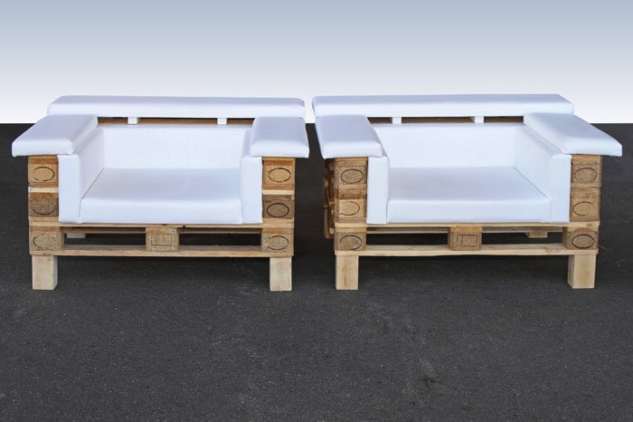 Deux fauteuils avec trois niveaux de palettes tout en blanc dans une pièce dotée d'un mur également de la même couleur. Sol gris uni.