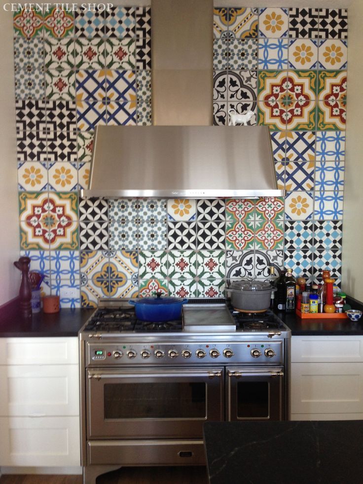 Carreaux de ciment blanc avec différentes formes et notamment des fleurs jaunes et diverses couleurs. Hotte en acier et grand four avec rangements tout blanc des deux côtés. carreaux de ciment 1