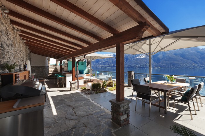 Cuisine de restaurant donnant sur le lac. Un aménagement idéal en été avec les parasols et la véranda ouverte sur la terrasse.