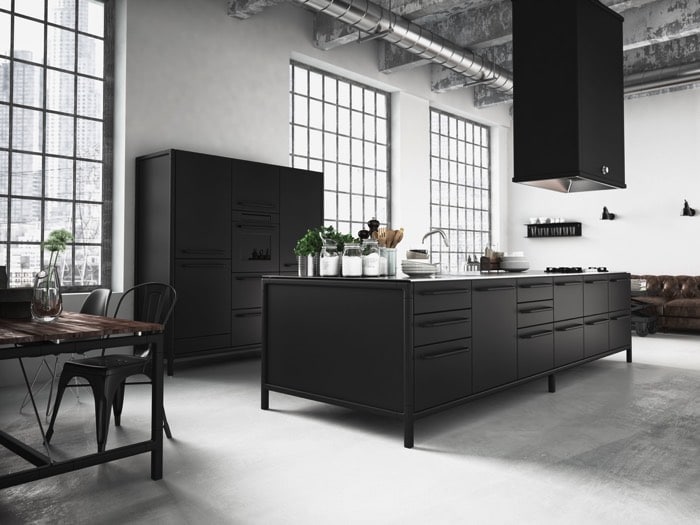 Cuisine moderne en gris anthracite avec îlot central rectangulaire et hotte en acier. Style industriel avec table en bois, rangements contre mur blanc et grandes fenêtres quadrillés.
