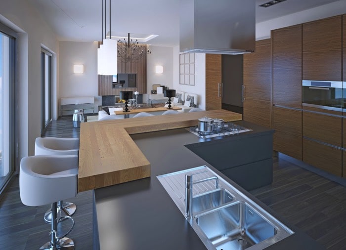 Cuisine en gris clair avec plan de travail en L et bar en bois chêne intégré. Évier en inox avec robinet mélangeur et égouttoir.