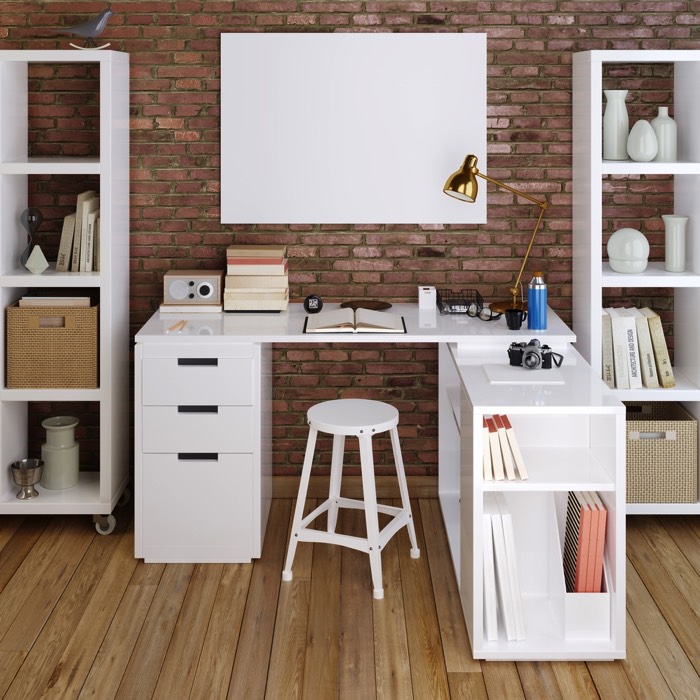 Aménagement d'un bureau en L blanc avec grand tableau rectangulaire minimaliste. Mur en briques rouges avec deux meubles de rangements des deux côtés.