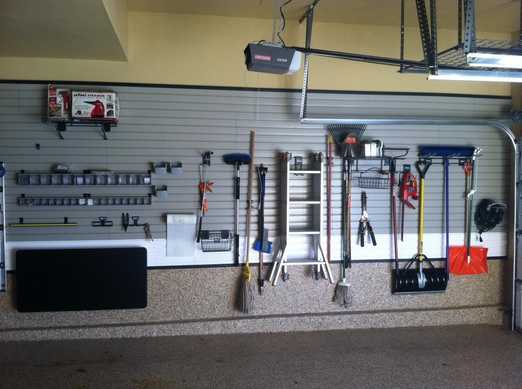 Idée de rangements pratiques pour un garage servant à accrocher des pelles, une échelle, des balais ou encore d'autres outils. Rangements en acier.