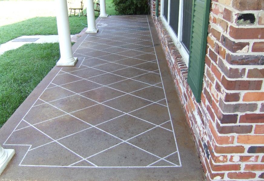 Peindre une terrasse à carreaux marrons avec piliers blancs et pelouse à proximité. Maison en vieilles pierres rouges avec fenêtre blanche et volets verts.
