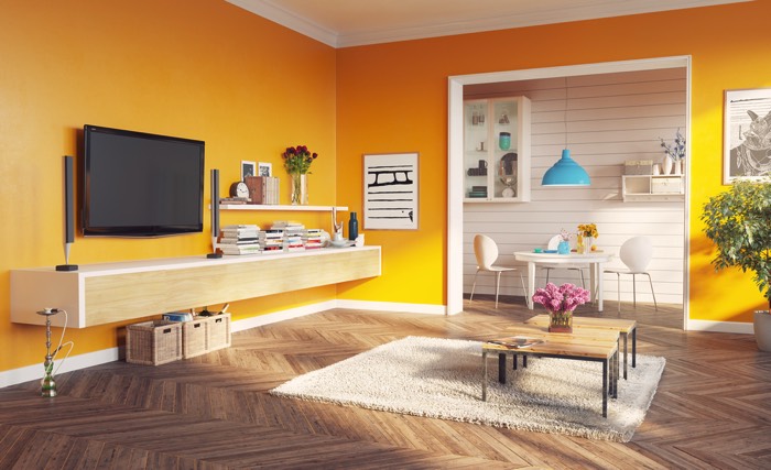 Salle à manger jaune style pop avec parquet en chêne. Table basse en bois et table blanche, deux sièges et lampe bleue claire suspendue.