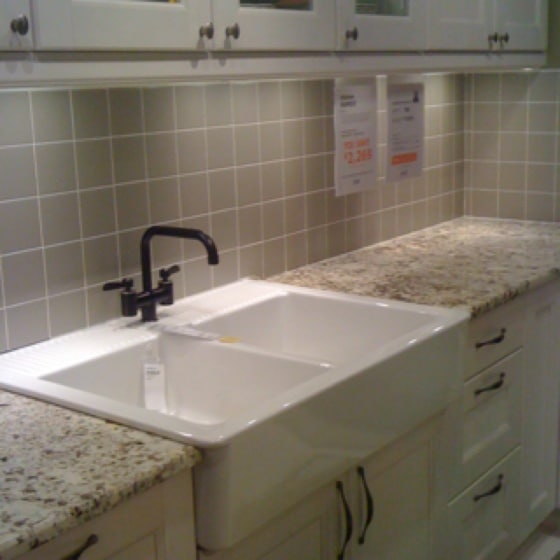 Évier blanc à poser sur plan travail avec 2 bacs avec robinet noir et carrelage mural beigeÉvier blanc avec 2 bacs avec robinet noir et carrelage mural