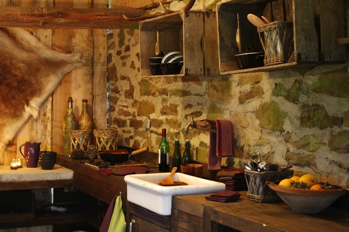 Évier blanc en céramique sur plan de travail en bois. Cuisine style chalet et rustique avec mur en pierre.Évier blanc en céramique sur plan de travail en bois. Cuisine style chalet et rustique avec mur en pierre.Évier blanc en céramique sur plan de travail en bois. Cuisine style chalet et rustique.