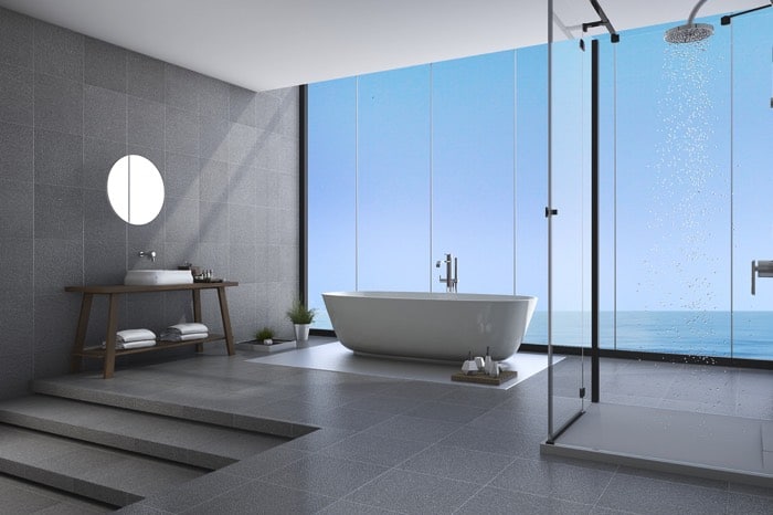 Salle de bain ouverte avec douche à l'italienne dotée d'une colonne de douche hydromassante. Receveur douche surélevé et paroi en verre. installation d'une colonne de douche hydromassante