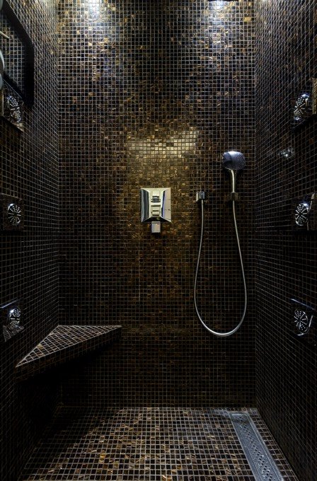 douche à l'italienne en mosaique noire et orange avec colonne de douche intégrée