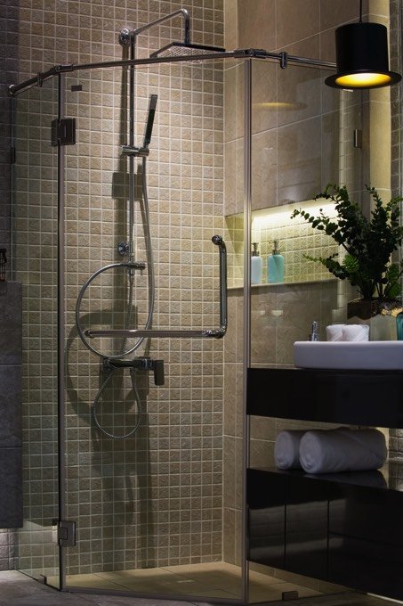 mur en mosaique beige foncé avec colonne de douche en inox avec fonction hydromassante