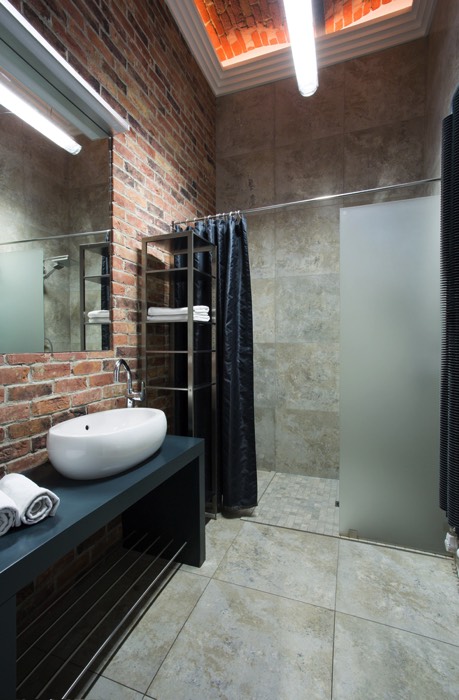 Une douche à l'italienne avec rideau de douche bleu foncé. Salle d'eau à l'ambiance street et industrielle.