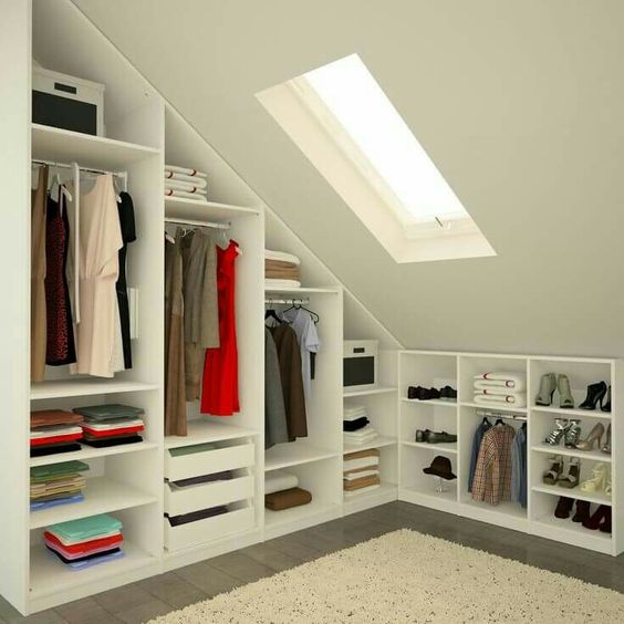 Placards sous pente blanc avec plusieurs rangements et fenêtrePlacards sous pente blanc avec plusieurs rangements et fenêtre Velux. Dressing avec moquette et tapis. Velux
