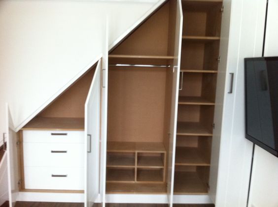 Placard mansardé en bois et blanc avec plusieurs cases de ranPlacard mansardé en bois et blanc avec plusieurs cases de rangement grandes et petitesgement