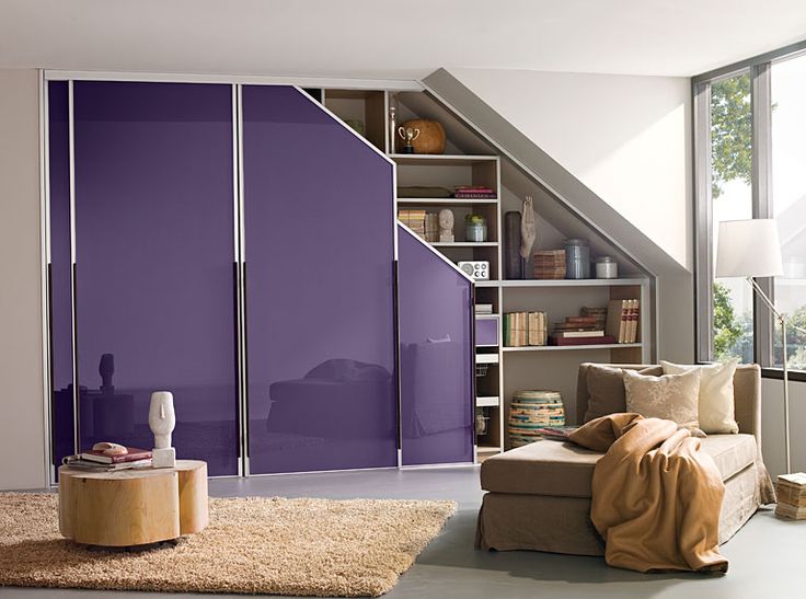 Chambre lumineuse munie d'un placard mansardé avec porte violetChambre blanche lumineuse et spacieuse munie d'un placard mansardé avec portes violettes servant de miroirte servant de miroir