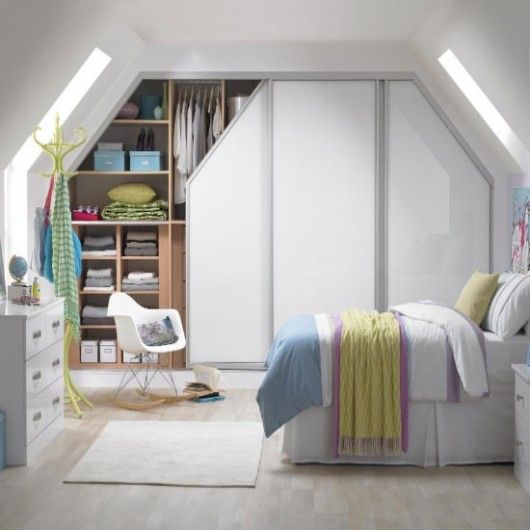 Placard mansardé avec porte blanche dans une chambre avec parquet