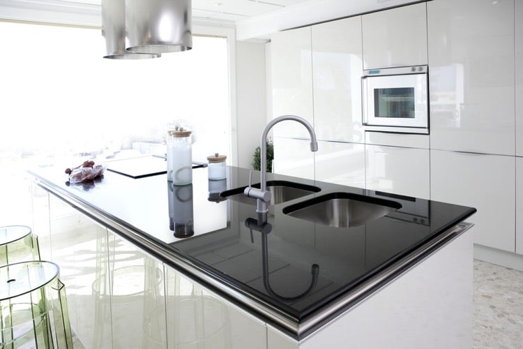 Deux éviers sous plan noir et blanc avec robinet mitigeur dans une cuisine lumineuse et spacieuse e et spacieuse cieuse