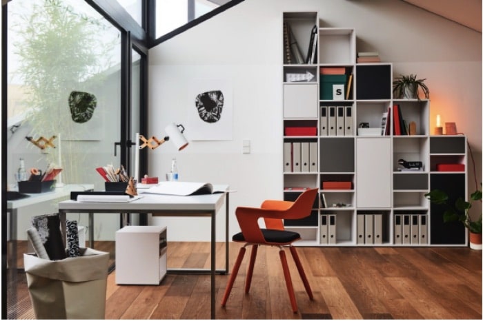 Aménager un bureau de design blanc avec chaise contemporaine orange et noire sur parquet. Rangements blanc en case. Aménager un bureau de design blanc avec chaise contemporaine orange sur parquet