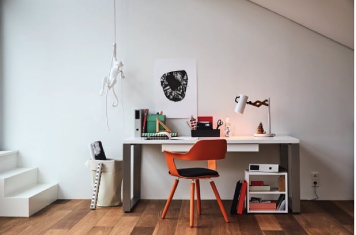 Espace de travail tout en blanc avec chaise design orange sur parquet