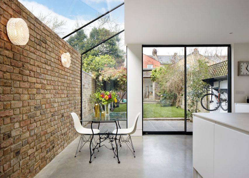 Extension de maison avec mur en brique de pierre et toit façon verrière