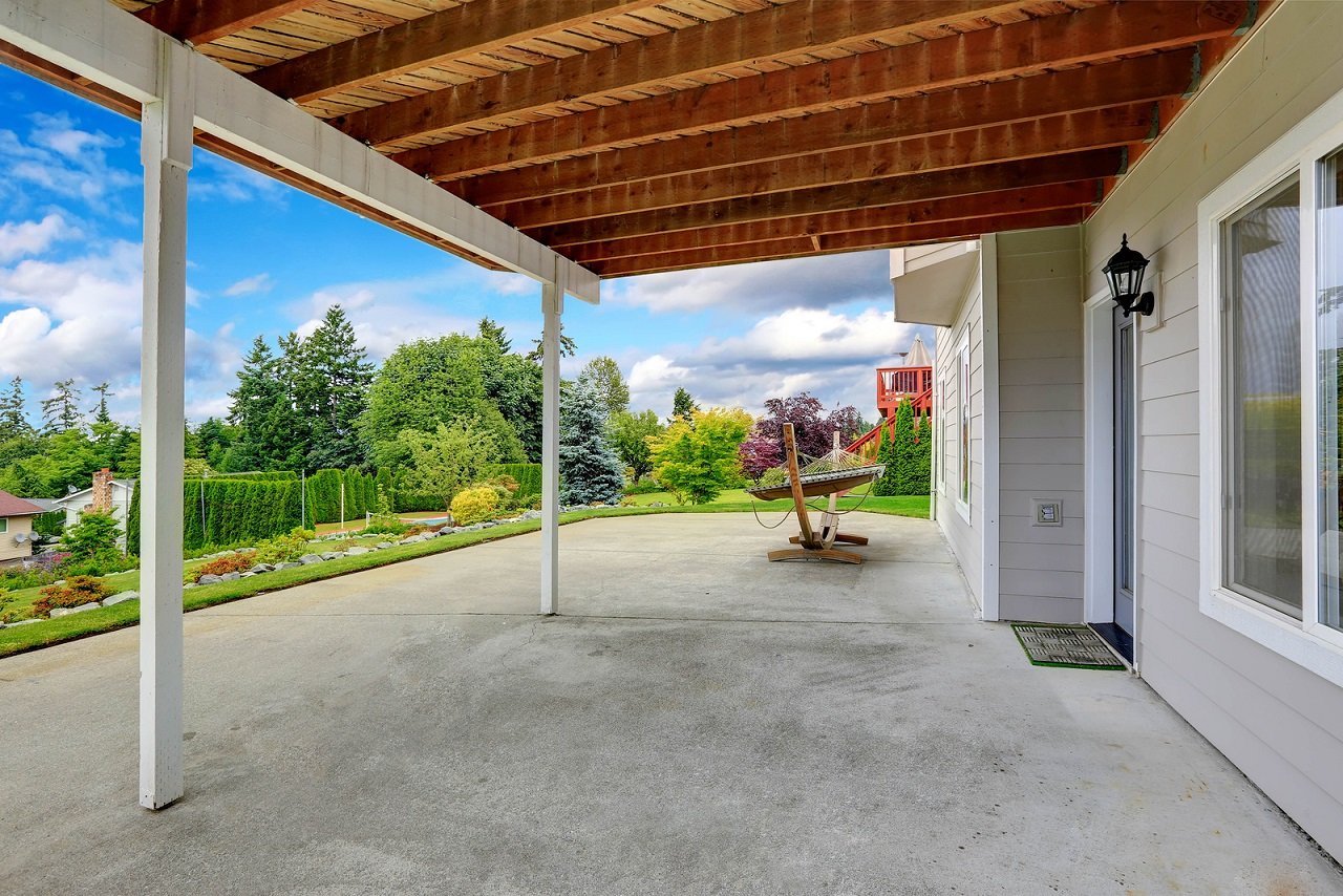 Une terrasse en béton sous une pergola