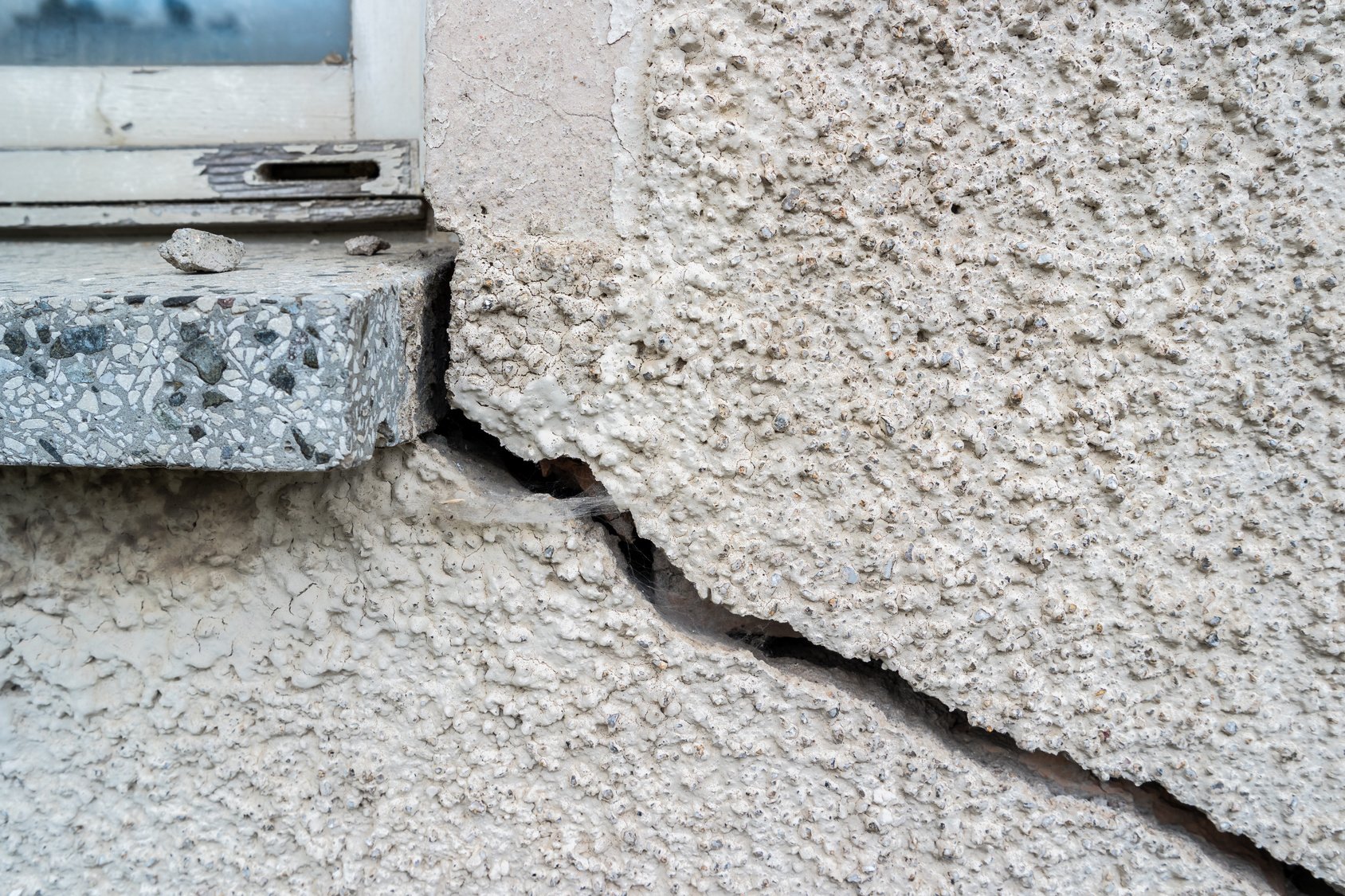 un mur lézardé près d'une fenêtre qu'il va falloir reboucher