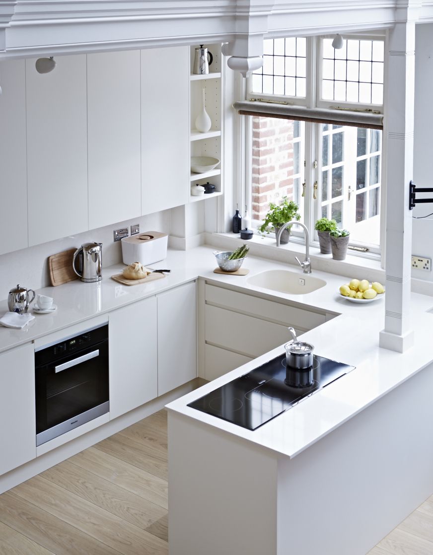 Vue plongeante sur une une cuisine blanche en U très moderne.