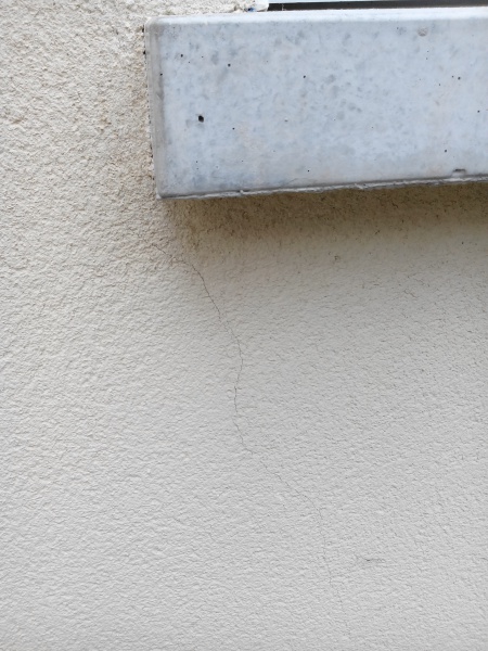 de petites fissure sur une façade à la suite d'infiltrations d'eau