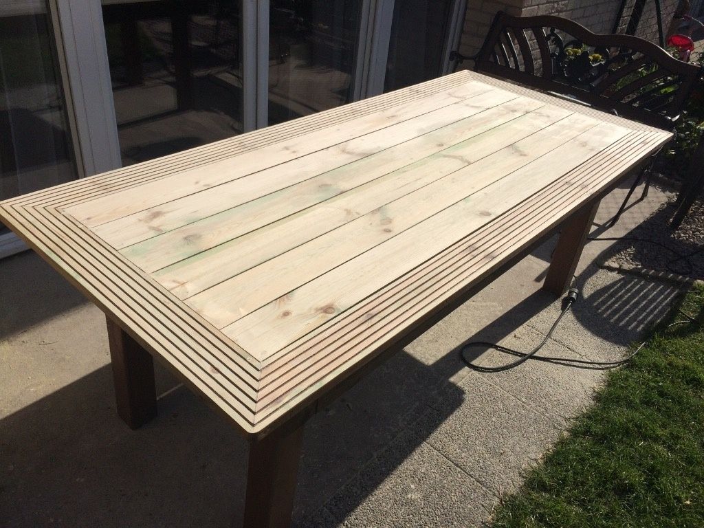 Une table de jardin en bois réalisée avec des lattes pour terrasse